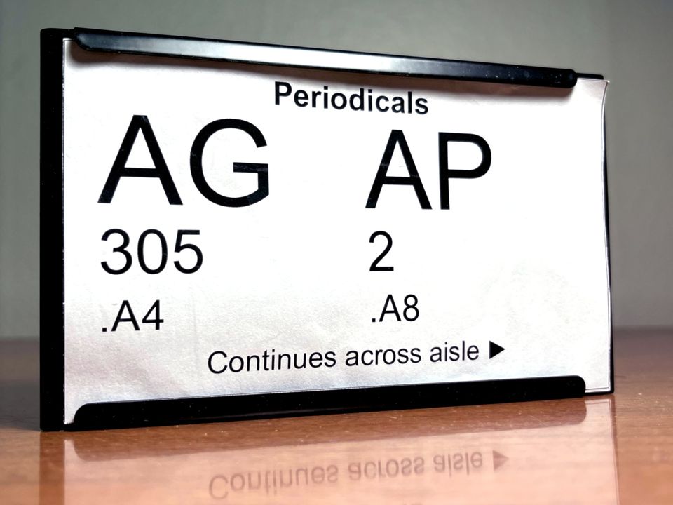 Photo of example signage which indicates the call number range for each row of books
